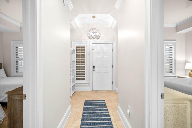 tiled foyer entrance with a notable chandelier and ornamental molding