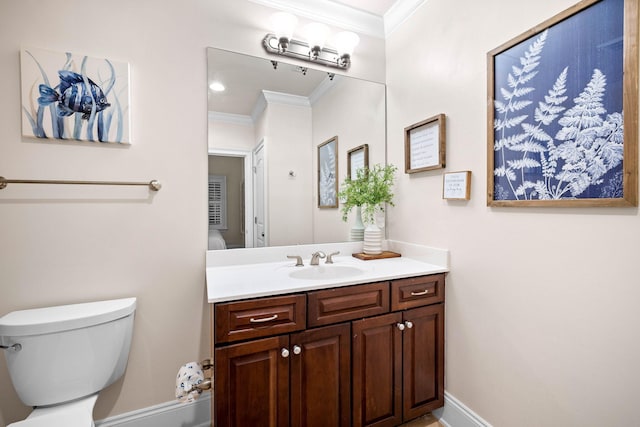 bathroom featuring vanity, toilet, and crown molding