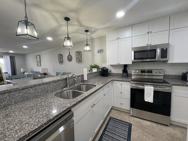 kitchen with white cabinetry, sink, hanging light fixtures, and appliances with stainless steel finishes