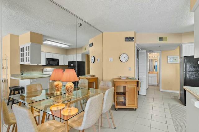 dining area with light tile patterned floors and a textured ceiling