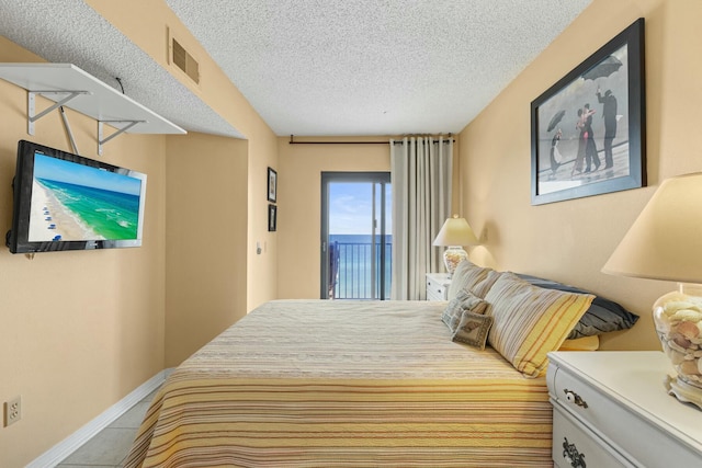 bedroom with light tile patterned floors and a textured ceiling