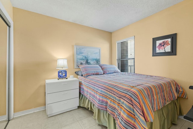 bedroom with light tile patterned floors and a textured ceiling