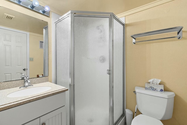 bathroom featuring vanity, toilet, and a shower with shower door