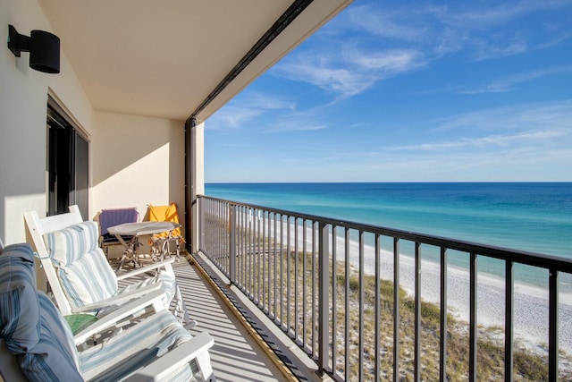 balcony featuring a view of the beach and a water view