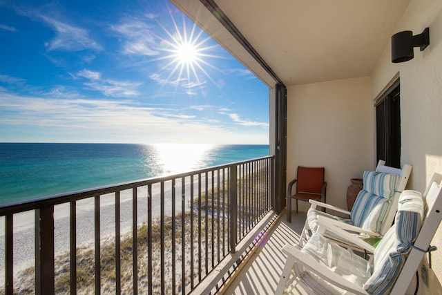 balcony with a water view and a view of the beach