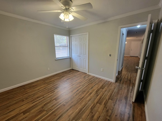 unfurnished bedroom featuring ceiling fan, dark hardwood / wood-style flooring, crown molding, and a closet