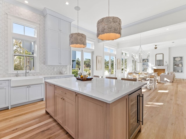 kitchen featuring decorative backsplash, sink, white cabinets, and a kitchen island