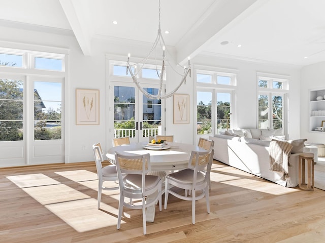 dining room featuring beam ceiling, light wood-type flooring, a notable chandelier, and french doors