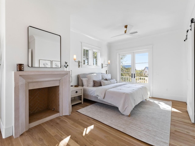 bedroom with ceiling fan, access to exterior, ornamental molding, and light hardwood / wood-style floors