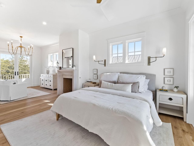 bedroom featuring crown molding, ceiling fan with notable chandelier, and light hardwood / wood-style floors