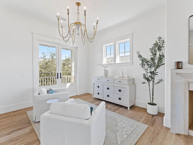 sitting room with an inviting chandelier, ornamental molding, and light wood-type flooring