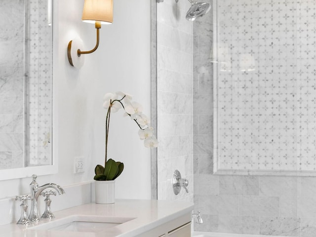 bathroom featuring tiled shower / bath combo and vanity