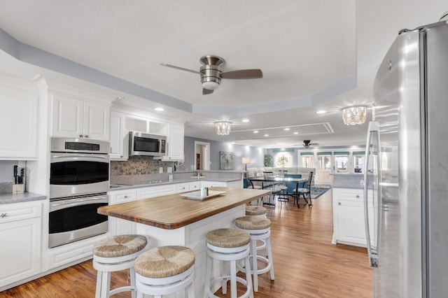 kitchen featuring wood counters, light wood-type flooring, white cabinetry, and stainless steel appliances