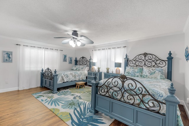 bedroom featuring ceiling fan, ornamental molding, a textured ceiling, and hardwood / wood-style flooring