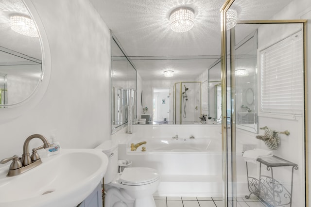 bathroom featuring vanity, a textured ceiling, a shower with door, tile patterned flooring, and toilet