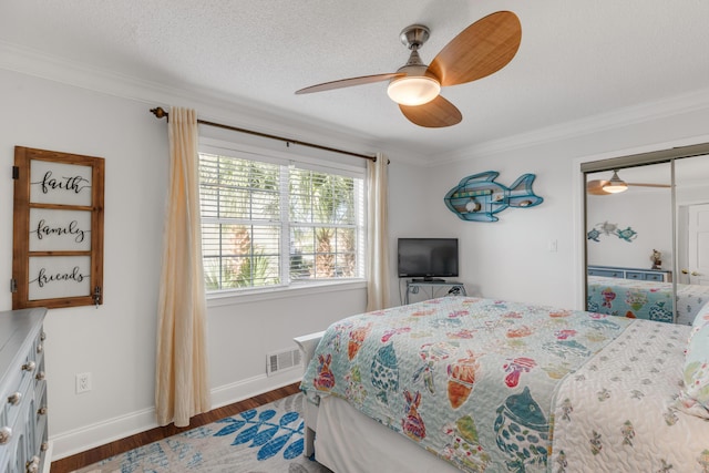 bedroom with ceiling fan, a closet, crown molding, and dark hardwood / wood-style floors