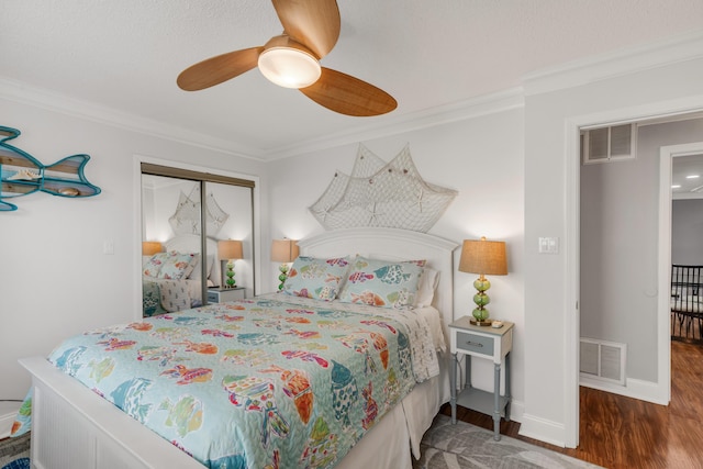 bedroom with dark hardwood / wood-style flooring, ceiling fan, a closet, and ornamental molding