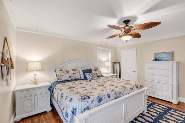 bedroom with ornamental molding, ceiling fan, and dark wood-type flooring