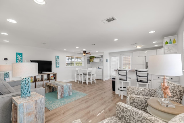 living room featuring ceiling fan and light wood-type flooring