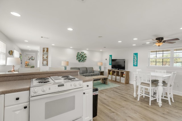 kitchen with white cabinets, ceiling fan, light wood-type flooring, and electric stove