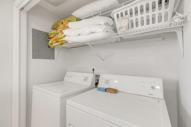 clothes washing area featuring electric panel and independent washer and dryer