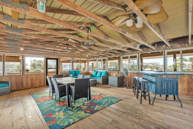 sunroom / solarium with lofted ceiling with beams, ceiling fan, and a wealth of natural light