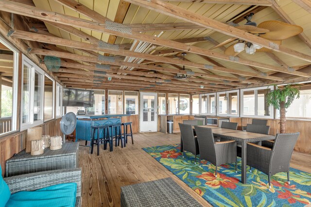 sunroom with vaulted ceiling with beams, a healthy amount of sunlight, and wooden ceiling