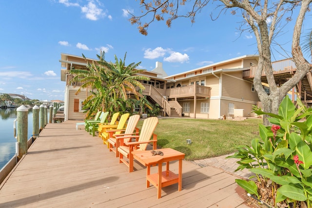 dock area featuring a yard and a deck with water view