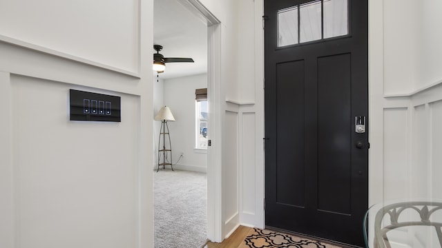 carpeted foyer entrance featuring ceiling fan