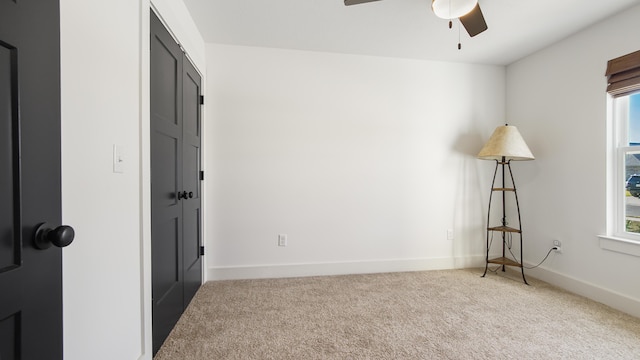 carpeted empty room featuring ceiling fan