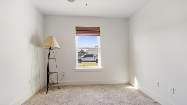 carpeted spare room featuring ceiling fan