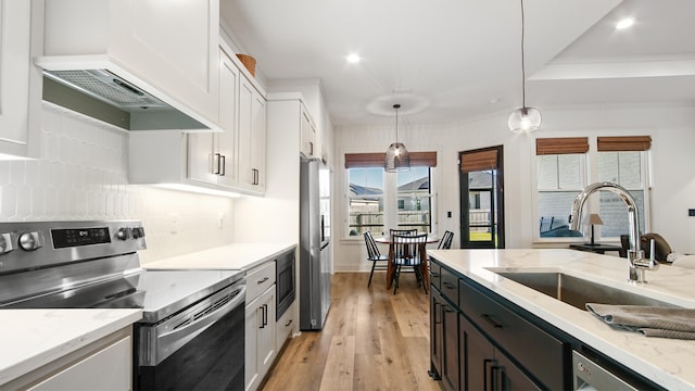 kitchen featuring stainless steel appliances, white cabinetry, hanging light fixtures, and custom exhaust hood