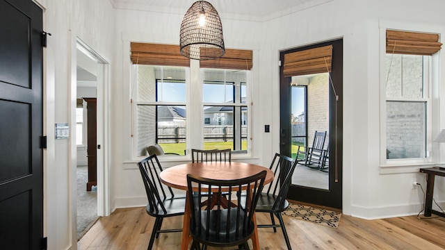 dining area with light hardwood / wood-style floors and ornamental molding