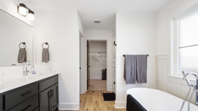 bathroom featuring a tub, plenty of natural light, vanity, and wood-type flooring