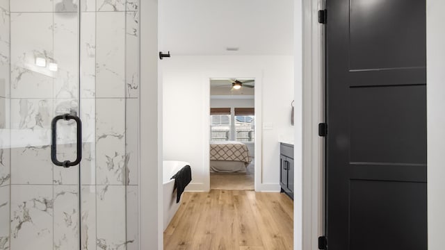 bathroom with a shower with door, vanity, and hardwood / wood-style flooring