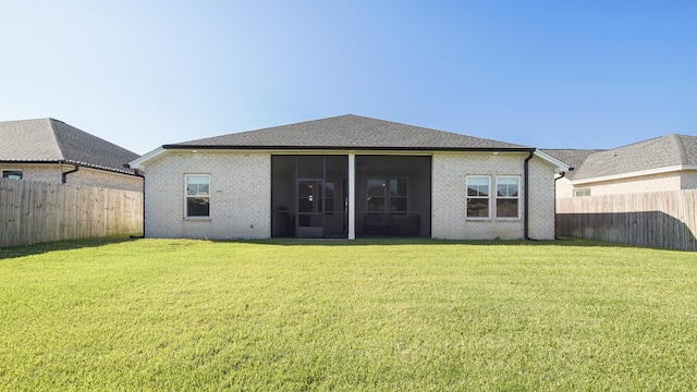 back of house with a lawn and a sunroom