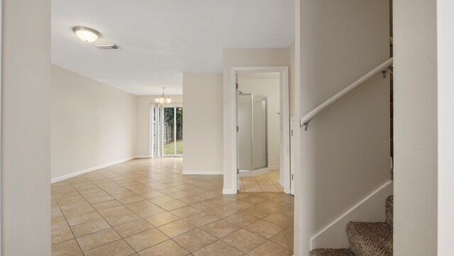 stairs featuring tile patterned flooring and a chandelier