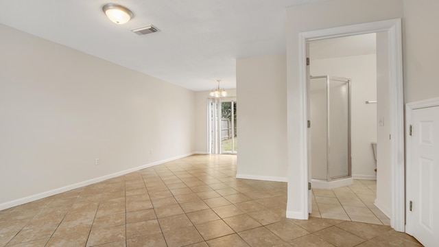 unfurnished room with light tile patterned floors and an inviting chandelier