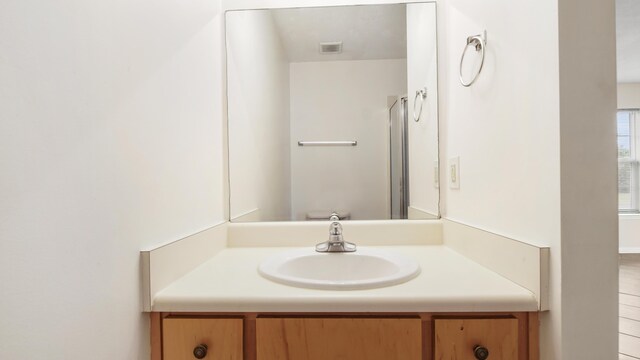 bathroom featuring vanity, toilet, and a shower with door