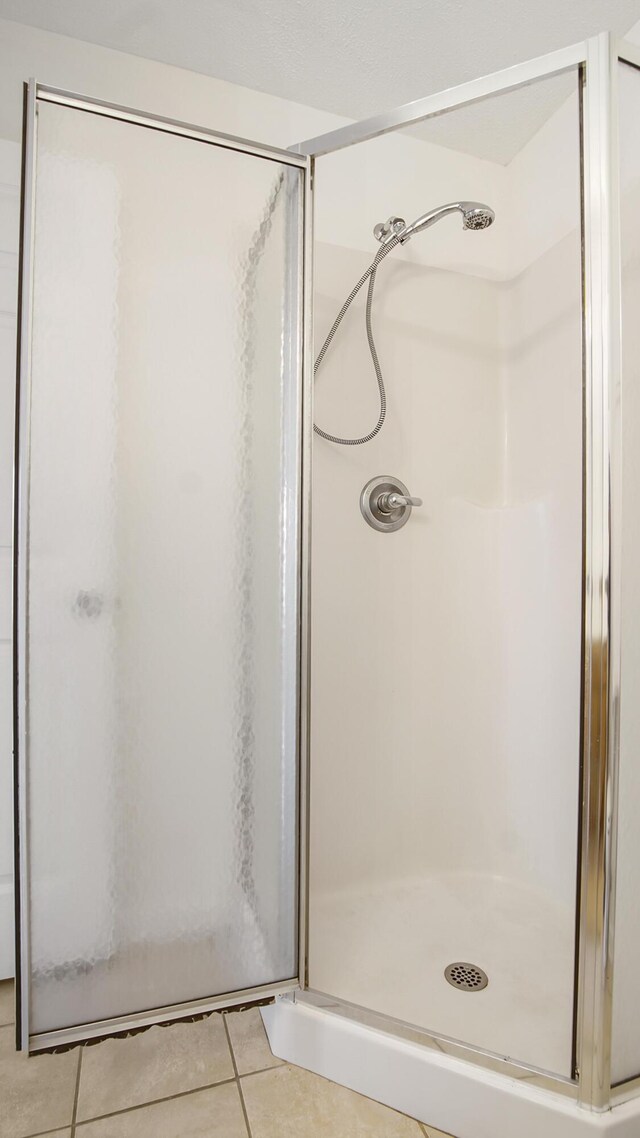 bathroom with tile patterned floors and walk in shower