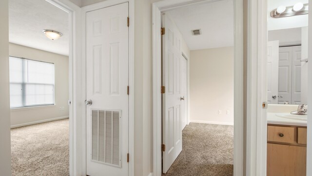 hall with carpet flooring and sink