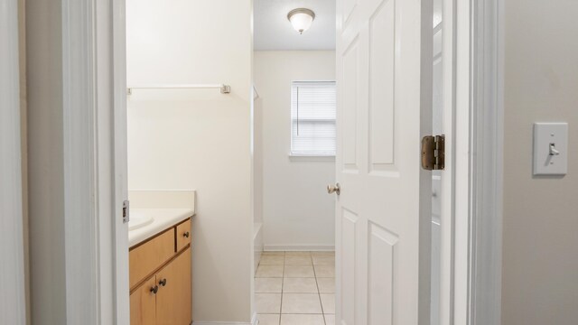 bathroom with tile patterned floors, vanity, and a bath