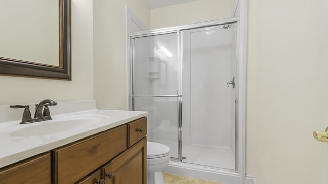 bathroom featuring vanity, toilet, and a shower with shower door