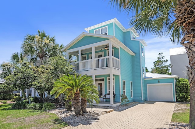 raised beach house featuring ceiling fan, a garage, and a balcony