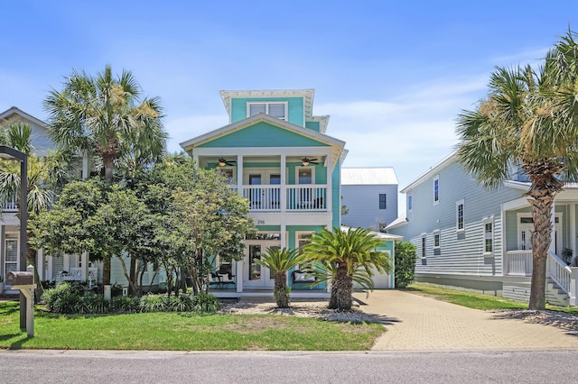 beach home featuring a balcony and a front lawn