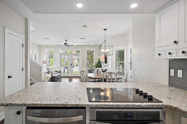 kitchen featuring white cabinetry, stainless steel oven, light stone countertops, black electric cooktop, and french doors