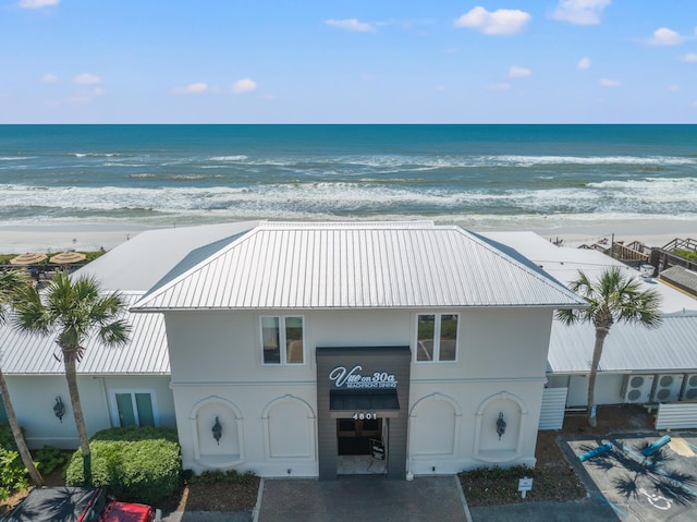 drone / aerial view featuring a water view and a view of the beach