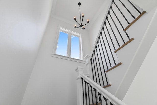 stairway featuring a notable chandelier