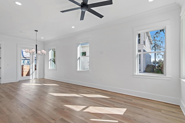 unfurnished living room featuring ceiling fan with notable chandelier, light wood-type flooring, and ornamental molding