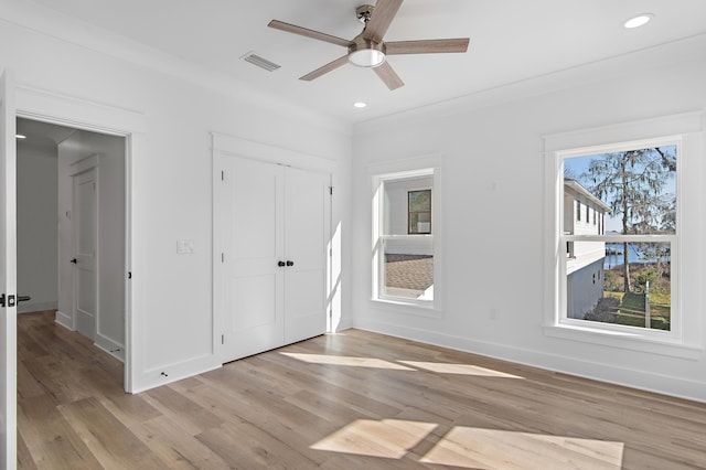 unfurnished bedroom with ceiling fan, light wood-type flooring, and crown molding